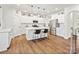 Spacious kitchen featuring white cabinetry, a center island, stainless steel appliances, and wood flooring at 1017 Cheviot Ct, Waxhaw, NC 28173