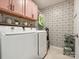 Laundry room with pink cabinets, modern wallpaper, washer and dryer at 1017 Cheviot Ct, Waxhaw, NC 28173