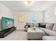 Inviting living room featuring a comfortable sectional sofa, modern media center, and natural light at 1017 Cheviot Ct, Waxhaw, NC 28173
