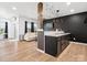 Open floorplan featuring living room and kitchenette with wood flooring and modern lighting at 1017 Cheviot Ct, Waxhaw, NC 28173