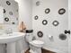 Stylish powder room featuring pedestal sink, toilet, and unique decorative mirror wall art at 1017 Cheviot Ct, Waxhaw, NC 28173