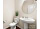 Clean half-bathroom with modern pedestal sink and round mirror at 113 Burlingame Ct # D, Mooresville, NC 28117