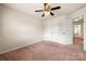Bedroom showcases neutral walls, plush carpet, and a ceiling fan with easy access to closets at 113 Burlingame Ct # D, Mooresville, NC 28117