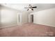 Spacious bedroom with ceiling fan, plush carpet, and neutral walls at 113 Burlingame Ct # D, Mooresville, NC 28117