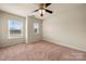 This bedroom has neutral walls, plush carpet, a ceiling fan, and two windows for natural light at 113 Burlingame Ct # D, Mooresville, NC 28117