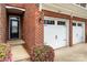 Close-up of brick townhome facade showing front door, garage, and landscaped entryway at 113 Burlingame Ct # D, Mooresville, NC 28117