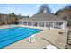 Community pool with a large pool house, chairs, covered seating areas, and lifeguard seat at 113 Burlingame Ct # D, Mooresville, NC 28117