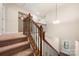 Carpeted staircase with wooden banister and decorative iron spindles at 113 Burlingame Ct # D, Mooresville, NC 28117