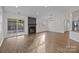 Bright, open living room with hardwood floors, fireplace, and sliding glass doors to a sunroom at 11501 Candlelight Ct, Charlotte, NC 28226