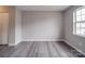An empty bedroom with gray vinyl floors, a double-door closet, and a bright window at 12601 Tucker Crossing Ln, Charlotte, NC 28273