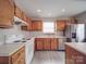 Well-lit kitchen featuring oak cabinets, white appliances, and stainless steel refrigerator at 12601 Tucker Crossing Ln, Charlotte, NC 28273