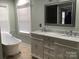 Bathroom with double sinks, a large mirror, and a soaking tub with chrome fixtures at 12662 Woodside Falls Rd, Pineville, NC 28134