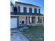 Olive green brick home with black shutters, white columns and a two car garage on a grassy lot at 12662 Woodside Falls Rd, Pineville, NC 28134