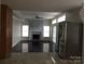 Open living room features hardwood floors, a stone fireplace, and glass doors leading to the backyard at 12662 Woodside Falls Rd, Pineville, NC 28134