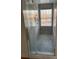 Shower with mosaic tiled floor, glass door, window, and temperature controls at 12662 Woodside Falls Rd, Pineville, NC 28134
