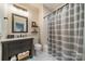 Well-lit bathroom with a gray vanity, marble countertop, and a shower with a striped curtain at 129 Tuckernuck Dr, Mooresville, NC 28117