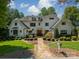 Beautiful two-story home featuring a stone walkway, manicured landscaping, and a welcoming front porch at 129 Tuckernuck Dr, Mooresville, NC 28117