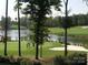 Scenic golf course view with a pond, green, sand traps, and golfers enjoying a game at 129 Tuckernuck Dr, Mooresville, NC 28117