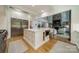 Open kitchen view features a large island, stainless refrigerator, and views of a living room with fireplace at 129 Tuckernuck Dr, Mooresville, NC 28117