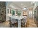 Bright, white kitchen features a large island, stone accent wall and stainless steel appliances at 129 Tuckernuck Dr, Mooresville, NC 28117