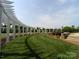 Manicured lawn and landscaping featuring a winding pergola walkway with lush green grass at 129 Tuckernuck Dr, Mooresville, NC 28117