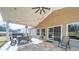 Relaxing covered patio with tile flooring, string lights, a dining table, and a view of a private backyard with a hot tub at 136 Falls Leaf Dr, Troutman, NC 28166