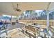 Inviting outdoor dining area on a covered patio, featuring a fan and view of the expansive, fenced backyard at 136 Falls Leaf Dr, Troutman, NC 28166