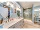 Bathroom with a modern dual sink vanity, decorative mirrors and a glass shower at 136 Falls Leaf Dr, Troutman, NC 28166