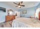 Comfortable bedroom features a ceiling fan, wood flooring and a decorative dresser with ornate mirror at 136 Falls Leaf Dr, Troutman, NC 28166