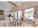 Dining area features a glass table, a chandelier, and large windows with a view to the backyard at 136 Falls Leaf Dr, Troutman, NC 28166