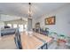 Dining room with natural wood table, modern lighting and open layout to living area at 136 Falls Leaf Dr, Troutman, NC 28166