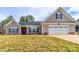 Charming single-story home featuring a two-car garage, well-manicured lawn, and inviting entrance with a decorative wreath at 136 Falls Leaf Dr, Troutman, NC 28166