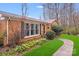 Charming brick home with a well-manicured lawn, walkway, and lovely flower bed featuring daffodils at 1377 Buckingham Ave, Gastonia, NC 28054