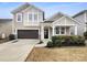 Charming two-story home showcasing a well-maintained yard, covered front porch, and attached garage at 1844 Burlington Dr, York, SC 29745
