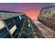 Dramatic view of a tall high rise building with balconies against a colorful sky at 210 N Church St # 1612, Charlotte, NC 28202