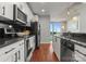 Modern kitchen featuring stainless steel appliances, sleek black backsplash, granite counters, and hardwood floors at 210 N Church St # 1612, Charlotte, NC 28202