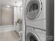 Small laundry room area adjacent to the bathroom featuring a stackable washer and dryer at 210 N Church St # 1612, Charlotte, NC 28202