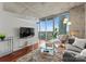 Bright living room with concrete ceilings, wood floors, a large balcony, and city views at 210 N Church St # 1612, Charlotte, NC 28202