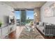 Bright living room with concrete ceilings, wood floors, a large balcony, and city views at 210 N Church St # 1612, Charlotte, NC 28202