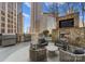 Cozy outdoor lounge with a stone fireplace, built-in TV, grilling area, and comfortable seating at 210 N Church St # 1612, Charlotte, NC 28202