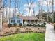 Charming blue home featuring a cozy front porch, mature landscaping, and a long driveway at 2400 Whirlaway Ct, Matthews, NC 28105