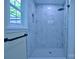 Well-lit bathroom shower featuring marble tiling, a shower head, window, and a modern towel rack at 315 Confederate St, Fort Mill, SC 29715