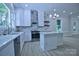 A well-designed kitchen featuring white cabinets, marble countertops, a stylish island, and stainless steel appliances at 315 Confederate St, Fort Mill, SC 29715