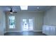 Bright living room featuring neutral walls, dark floors, ceiling fan and french doors to outdoor patio at 315 Confederate St, Fort Mill, SC 29715