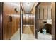 Hallway with wood paneled walls and carpet that leads to other rooms of the property at 32 Bowen Dr, Belmont, NC 28012
