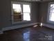 Bedroom featuring hardwood floors and multiple windows for natural light at 322 E Houston St, Monroe, NC 28112