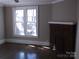 Sunlit living room featuring a charming brick fireplace and hardwood floors at 322 E Houston St, Monroe, NC 28112