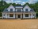 Stunning exterior of a two-story modern farmhouse with black trim windows and a welcoming front porch at 4024 Landsford Rd, Marshville, NC 28103