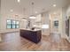 The kitchen is part of an open concept living space and boasts a spacious center island and stainless appliances at 4024 Landsford Rd, Marshville, NC 28103