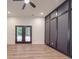 Living room with wood floors, black accent wall, recessed lights, ceiling fan, and French doors to backyard at 4024 Landsford Rd, Marshville, NC 28103